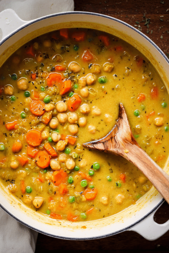 Hearty one-pot creamy vegetable soup with chickpeas, carrots, and peas simmered in a rich golden broth for comfort